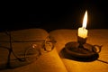 Vintage glasses on a bible lit by candlelight