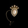 Vintage gold brooch in the shape of a crown with pearls.