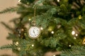 Vintage gold old retro clocks hang on branch of green Christmas tree background. Photo for greeting cards. Xmas mood. Decorated