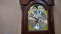 Vintage grandfather clock ticking on wall