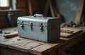 Vintage gray metal toolbox sits on rough wooden table. Rusty clasps secure box containing tools in workshop. Retro container for Royalty Free Stock Photo