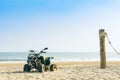 Vintage green ATV on the sandy beach. Quad ATV all terrain vehicle parked on beach, Motor bikes ready for action with summer sun Royalty Free Stock Photo