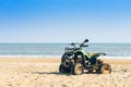 Vintage green ATV on the sandy beach. Quad ATV all terrain vehicle parked on beach, Motor bikes ready for action with summer sun Royalty Free Stock Photo