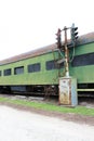 Vintage green railway passenger car with partially boarded windows and old railway track light Royalty Free Stock Photo