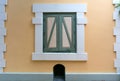 Vintage green window in the white frame on the wall is light yellow cement Royalty Free Stock Photo