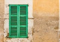 Vintage green wooden window shutters and old stone wall background Royalty Free Stock Photo