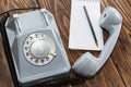 Vintage grey phone, writing pad on wooden background close-up, top view Royalty Free Stock Photo