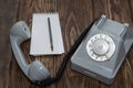 Vintage grey phone, writing pad on wooden background close-up, top view Royalty Free Stock Photo