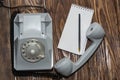 Vintage grey phone, writing pad on wooden background close-up, top view Royalty Free Stock Photo
