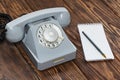 Vintage grey phone, writing pad on wooden background close-up, top view Royalty Free Stock Photo