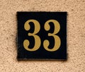 Vintage grunge square metal rusty plate of number of street address with number. 33 Royalty Free Stock Photo