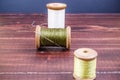 Vintage grunge three wooden thread spool with needle Royalty Free Stock Photo