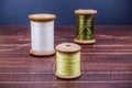 Vintage grunge three wooden thread spool with needle Royalty Free Stock Photo