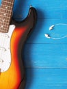 Vintage guitar with earphones on wood Royalty Free Stock Photo