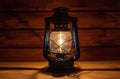 Vintage hand-held kerosene lamp illuminates with a soft glow in a dark room on the table. Vintage style. Light in the dark.
