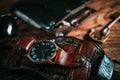 Vintage hand watch with leather watchband, wallet and key on wooden background