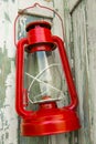 Red vintage handle gas lantern on rustic wooden wall. Royalty Free Stock Photo