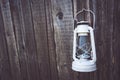 White vintage handle gas lantern on rustic wooden wall. Royalty Free Stock Photo