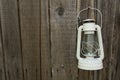 White vintage handle gas lantern on rustic wooden wall. Royalty Free Stock Photo