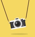 Vintage hanging camera on color background concept