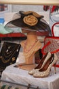 Vintage hat on mannequin head with pearls and high heeled shoes on side at flea market