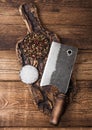 Vintage hatchet for meat on wooden chopping board with salt and pepper on wooden table background