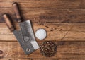 Vintage hatchets for meat with salt and pepper on wooden table background. Space for text