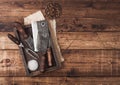 Vintage hatchets for meat in wooden box with salt and pepper on wooden table background with linen towel and fork and knife. Top