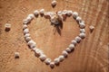 Vintage heart contour maid of cherry petals on cracked wooden background with shallow depth