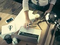 Vintage hipster wooden desktop top view, male hands using a laptop and holding a pencil Royalty Free Stock Photo