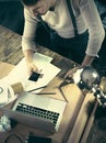 Vintage hipster wooden desktop top view, male hands using a laptop and holding a pencil Royalty Free Stock Photo