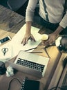 Vintage hipster wooden desktop top view, male hands using a laptop and holding a pencil Royalty Free Stock Photo