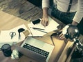 Vintage hipster wooden desktop top view, male hands using a laptop and holding a pencil