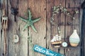 Vintage holidays still life with rope, starfish, compass and bottle on old wooden background Royalty Free Stock Photo