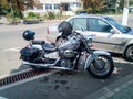 Vintage Honda motorcycle in the parking lot next to the car