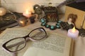 Vintage horizontal still life: printed book, candle glasses, vintage jewelry, small faience doll