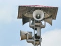 Vintage horn speaker tower with loudspeaker against the sky.