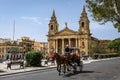 A vintage horse carriage in the street of Floriana, Malta. Saint Publius Parish church.