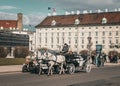 Vintage horse-drawn carriage navigating a historic cobblestone street in Vienna, Austria