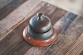 Vintage hotel reception service desk bell on wooden table. Royalty Free Stock Photo