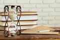 Vintage hourglass against a stack of old books Royalty Free Stock Photo