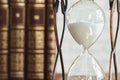 Vintage hourglass against a stack of old books Royalty Free Stock Photo