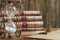 Vintage hourglass against a stack of old books close up Royalty Free Stock Photo