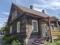 Old historic wooden house with a porch and steps, under a blue sky and with a tin roof. Royalty Free Stock Photo