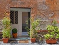 A vintage house exterior with white entrance door on ocher wall and flower pots Royalty Free Stock Photo