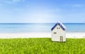 Vintage house model on green grass with space on blurred summer beach background Royalty Free Stock Photo