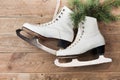 Vintage ice skates for figure skating with fir tree branch hanging on rustic background. Christmas decoration. Royalty Free Stock Photo