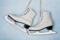 Vintage ice skates for figure skating hanging on the background of blue wall. Royalty Free Stock Photo