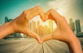 Vintage image of Heart Shaped Hand with blurred Singapore city