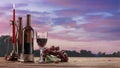 Vintage image of traditional romantic date. Two wine bottles on wooden table isolated over sunset background. Nature Royalty Free Stock Photo